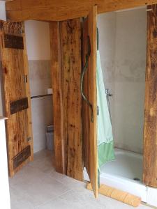 a bathroom with a wooden door and a bath tub at Adriatrek Bed & Breakfast in Petrovac na Moru