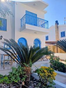 a house with a balcony and a palm tree at Latchi Holiday House in Prodhromi
