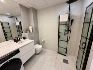 a bathroom with a toilet and a glass shower at Apartment Targowa L9 in Lublin +13 photos