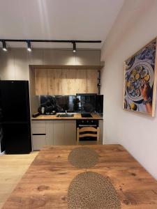 a kitchen with a wooden table in a room at Coral Studio Apartment in Shëngjin +11 photos