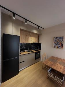 a kitchen with a black refrigerator and a table at Coral Studio Apartment in Shëngjin