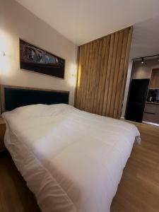 a bedroom with a white bed and a large window at Coral Studio Apartment in Shëngjin