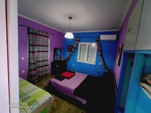 a bedroom with purple and blue walls and a bed at House Lantana 1432 in Pentátion