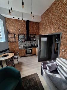 a living room with a couch and a brick wall at Apartman Duga in Kula +8 photos