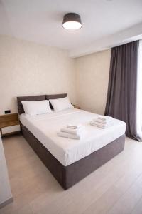 a bedroom with a large bed with white sheets at DreamSide Aparthotel in Batumi