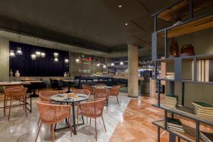 a restaurant with tables and chairs and a bar at Hotel SB Express Tarragona in Tarragona