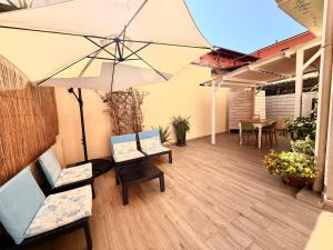 a patio with two chairs and an umbrella at Casa Vacanze Roberta in Follonica