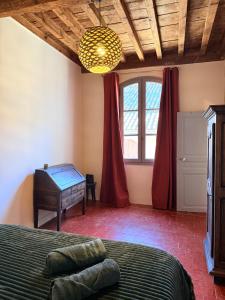 a bedroom with a bed and a dresser and a window at Le Voisin des Arènes in Arles