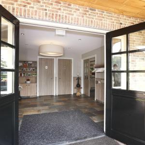 an open room with a brick wall and a black door at De Sterre in Losser
