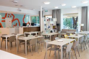 a restaurant with tables and chairs in a room at MICAMPA Wien Wienerwald in Vienna