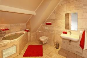 a bathroom with a tub and a toilet and a sink at De Sterre in Losser +71 photos