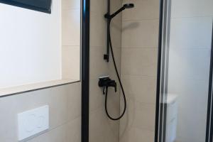 a shower with a shower head in a bathroom at MICAMPA Wien Wienerwald in Vienna +57 photos