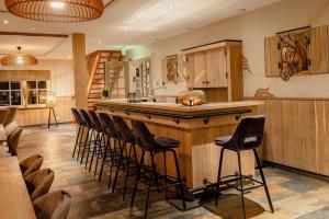 a kitchen with a bar with a sink and some stools at De Sterre in Losser