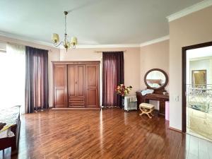 a living room with a wooden floor and a mirror at Aisi Villa in Misakʼtsʼieli +19 photos