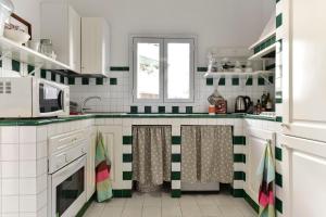 ローマにあるMaru Apartmentの緑と白のタイル張りの壁のキッチン