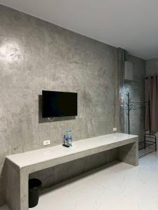 a living room with a tv on a wall at K-Am คราม อมตะ รีสอร์ต in Ban Yan Su