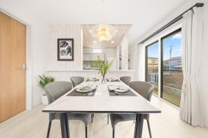 a white dining room with a table and chairs at Liber 1 Tachikawa in Tachikawa