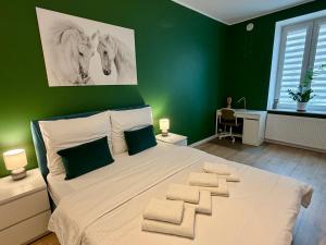 a bedroom with a large bed with green walls at Apartment Targowa L9 in Lublin