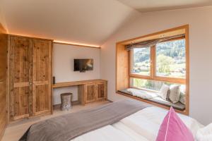 a bedroom with a bed and a large window at Bio Chalets Alpegg in Waidring