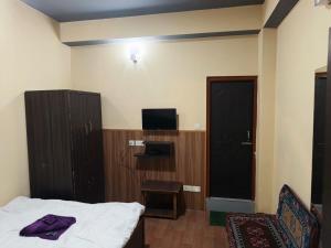a hotel room with a bed and a tv and a room at Great Eastern Valley Residency in Gangtok