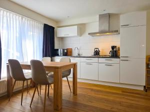 a kitchen with a wooden table and white cabinets at Vakantiewoning Veere VE01 in Veere
