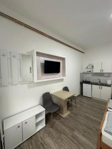 a room with a table and chairs and a kitchen at Apartman Milanović in Pribojska Banja