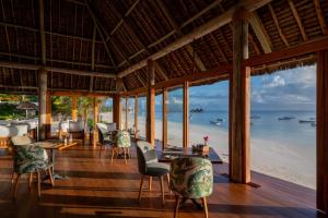 a restaurant on the beach with tables and chairs at Ocean Boutique Hotel - Adults only in Pingwe +64 photos
