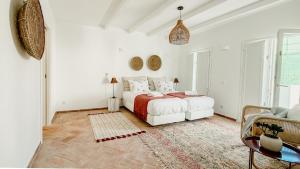 a white bedroom with a bed and a couch at Casa do Céu - Casas do Levante in Olhão