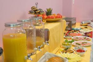 a table topped with jars of orange juice and plates of food at Floryda in Jurata +12 photos