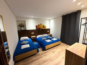 two beds in a room with blue sheets at Casa da Belavista in Trofa +44 photos
