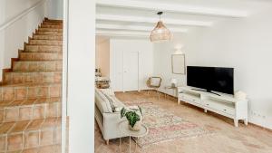 a living room with a staircase and a television at Casa do Céu - Casas do Levante in Olhão
