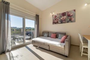 a living room with a bed and a large window at ElGio Maisonette Nikiti in Nikiti