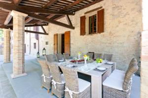 an outdoor dining room with a table and chairs at Villa Benveduti in Gubbio