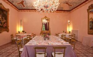 a dining room with tables and chairs and a chandelier at Villa Benveduti in Gubbio