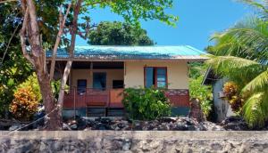 a house on the beach with rocks in front of it at Bunaken Sunrise Beach in Manado