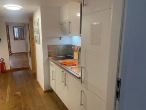 a kitchen with white cabinets and a sink at FeWo Sonne in Konstanz +10 photos