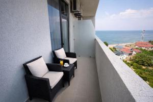 a balcony with chairs and a view of the ocean at DreamSide Aparthotel in Batumi