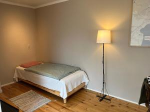 a small bedroom with a bed and a lamp at Rinkenæshus Das Grosses Zimmer in Gråsten