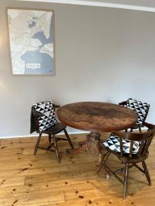 a wooden table with two chairs and a table with at Rinkenæshus Das Grosses Zimmer in Gråsten