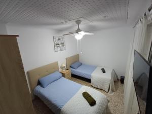 a bedroom with two beds and a ceiling fan at PARRA HOME y Garaje, Algemesi Home in Algemesí