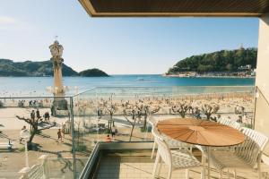 a balcony with a table and chairs and a beach at LA CONCHA BEACHVIEW by SWEET HOME SAN SEBASTIAN in San Sebastián