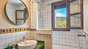 a bathroom with a sink and a mirror and a window at Casa Olea in Priego de Córdoba