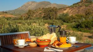 a table with a breakfast of bread and orange juice at Casa Olea in Priego de Córdoba