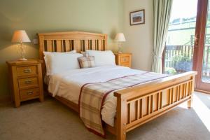 a bedroom with a large bed and a window at Plum Tree Lodge in Errol