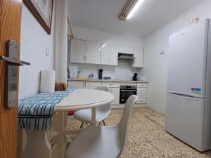 a kitchen with a table and chairs and a refrigerator at PARRA HOME y Garaje, Algemesi Home in Algemesí