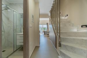 a bathroom with a staircase and a glass shower at ElGio Maisonette Nikiti in Nikiti +16 photos