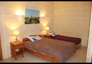a bedroom with two beds and two lamps in it at Shamrock House in Qala +3 photos