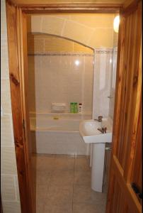 a bathroom with a bath tub and a sink at Shamrock House in Qala