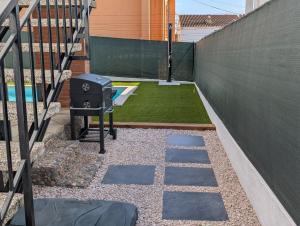a backyard with a grill and a fence at VILLA Pinemar & Relax in Pineda de Mar +58 photos