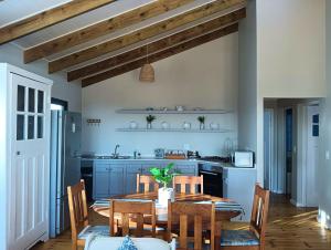 a kitchen with a wooden table and a kitchen with blue cabinets at Beach Walk by Salted Fynbos Staying in Pearly Beach